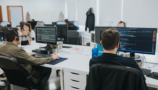 office with a team of programmers specialising in web accessibility consultancy sitting at their workstations in front of a computer.