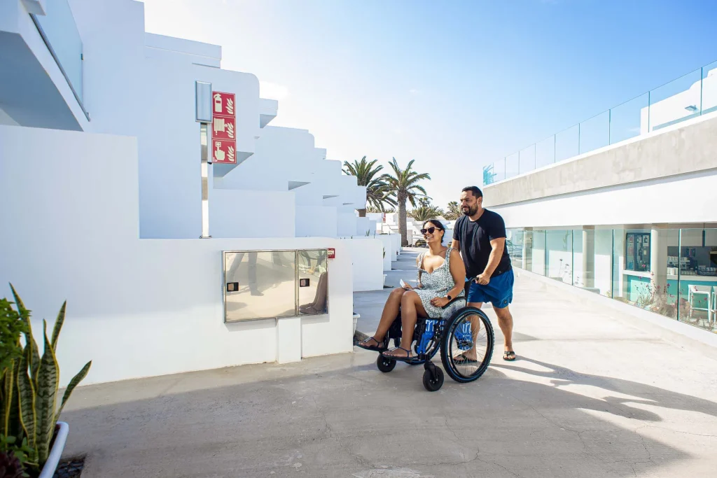 Hola chica sobre silla de ruedas, disfruta con su pareja de las instalaciones accesibles del Hotel Taimar.